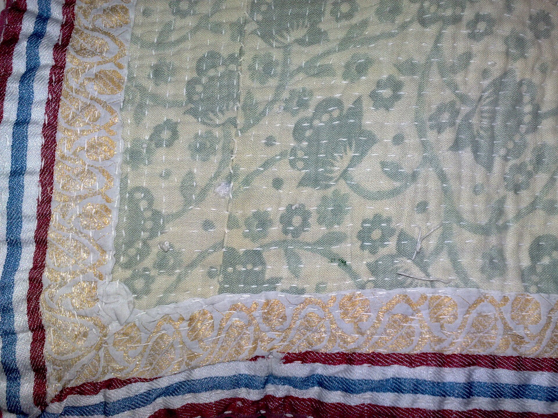 Close view of colorful hand stitching on a kantha textile